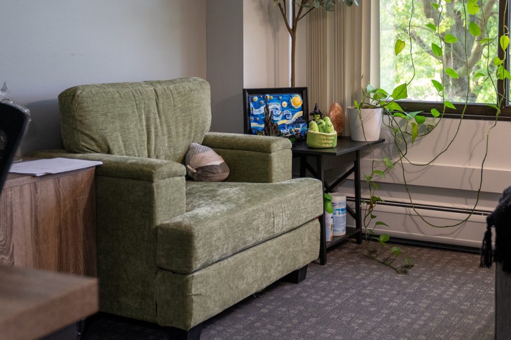 A comfortable and private counseling office setting featuring a green armchair and an accent table, providing a safe space for confidential substance use assessments.